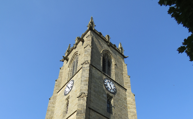 A stone clock tower set against the backdrop of a clear blue sky